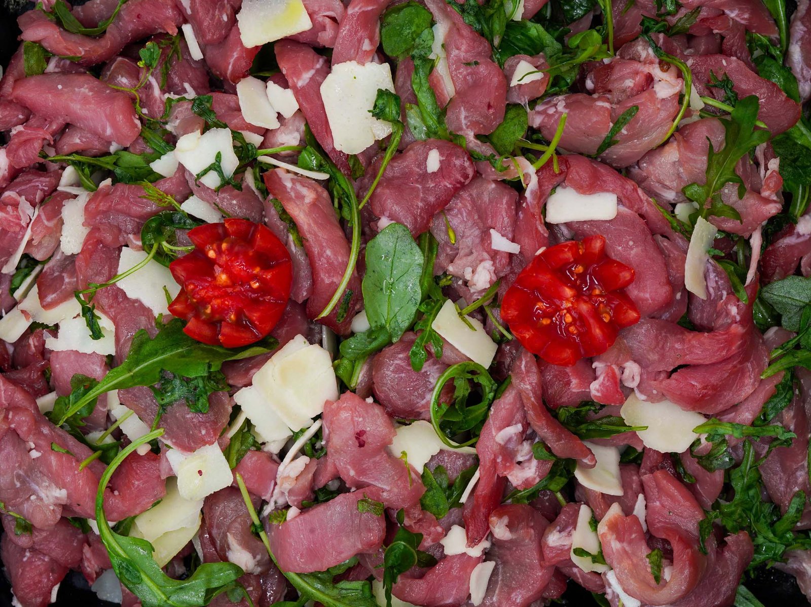 Straccetti di maiale con rucola pomodorini e grana